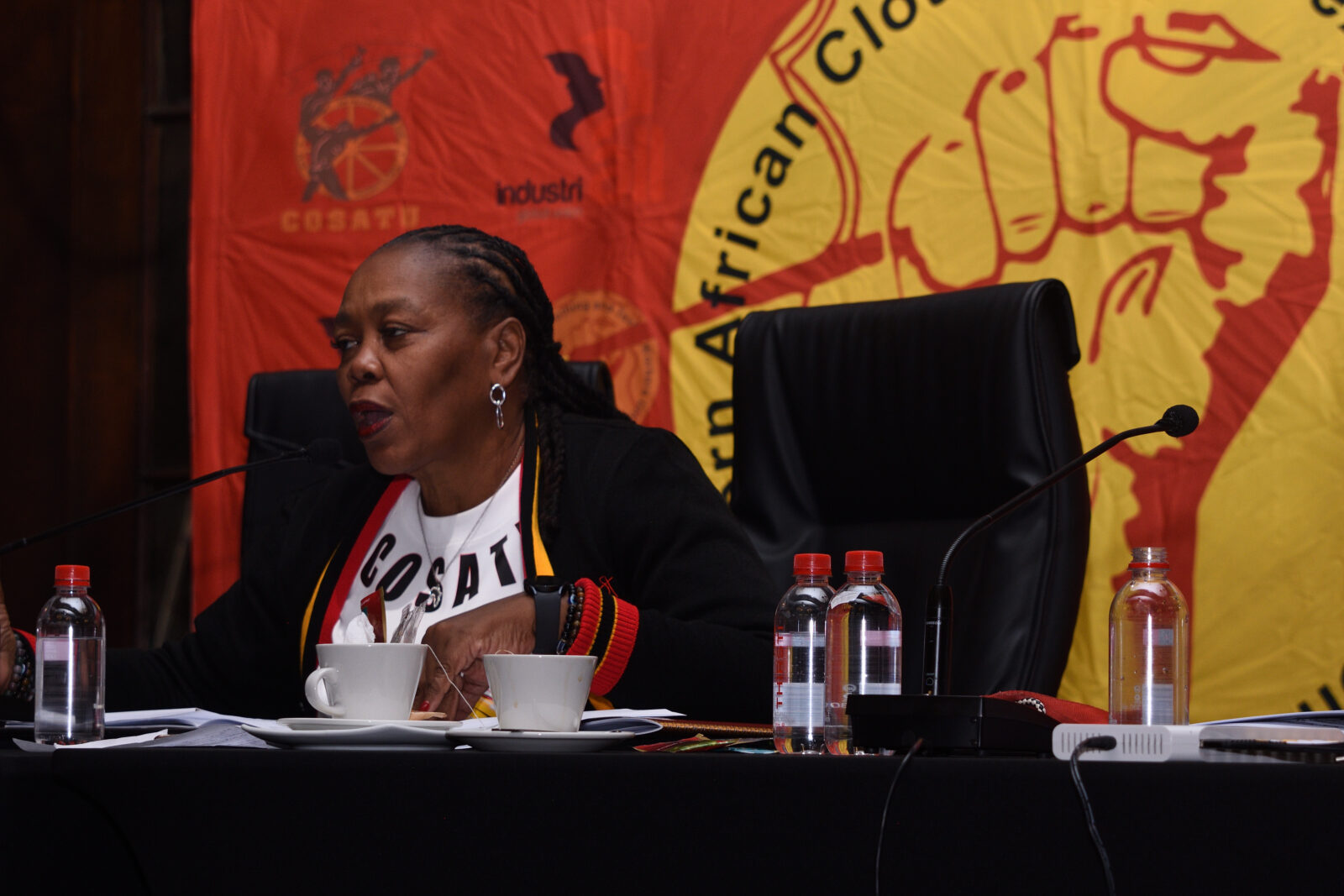 COSATU president Susan Khumalo speaking at SACTWU conference with COSATU and SACTWU banners behind her, Cape Town, March 2026
